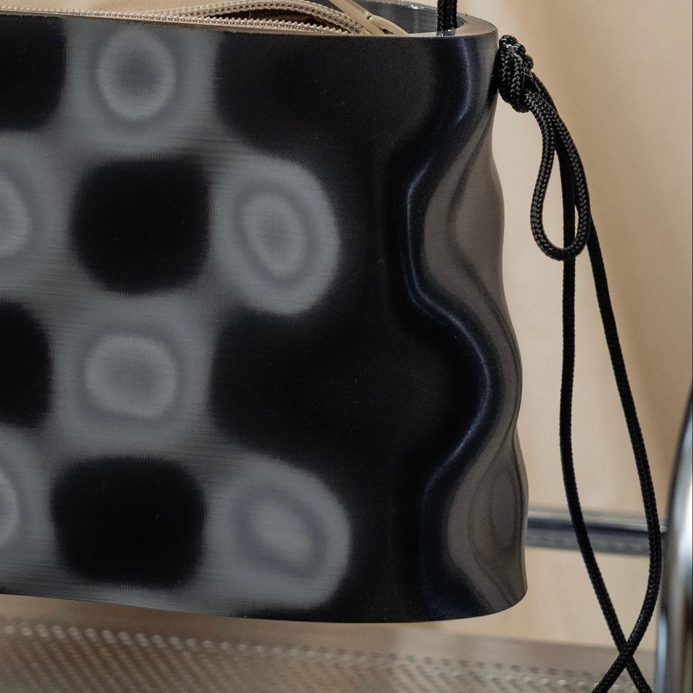 Close-up of LIQUID sculptural handbag with translucent handle and cord detail.